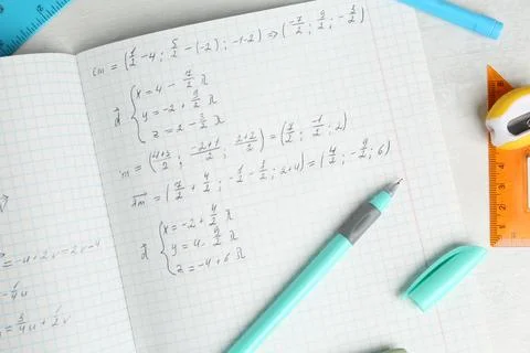 Doing homework. Notebook with math assignment and stationery on white desk,.. Stock Photos