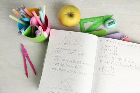 Doing homework. Notebook with math assignment, apple and stationery on whit.. Stock Photos