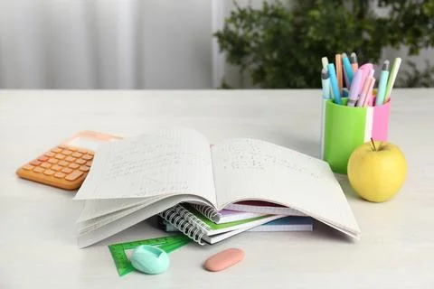 Doing homework. Notebook with math assignment, apple and stationery on whit.. Stock Photos