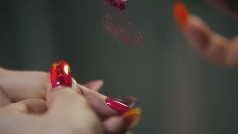 Doing manicure - applying sparkles on the pink nail with a small flat brush Stock Footage 130037611