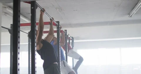 Doing pull-ups, men exercising on pull-up bars in gym, building strength, copy Vídeos de archivo 299232052