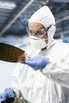 Doing quality control on silicon wafers, man and safety sterile bunny suit Stock Photos