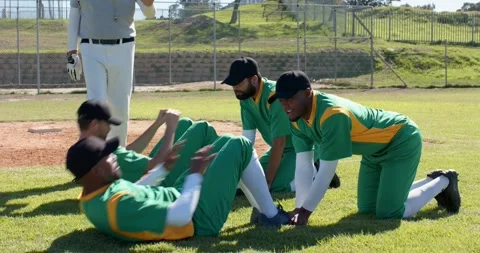 Doing situps two African American male baseball players receiving bat reps on 動画素材 342018012
