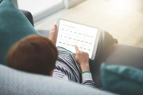 Doing some math in the morning. a focused little boy browsing on a digital Stock Photos