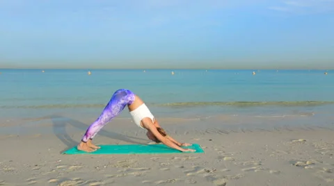 Doing yoga by the sea on the sand Stock Footage 63369865
