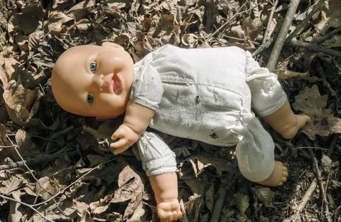 The doll abandoned in the forest. Stock Photos