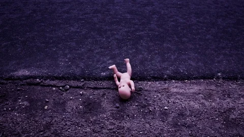 The doll falls to the ground (asphalt, sand, grass) Video stock 76376151