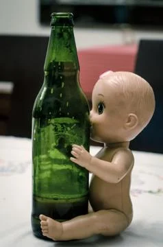 Doll hugging beer bottle Stock Photos