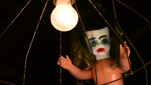 Doll looks at a light bulb in an old lampshade Stock Footage 135386741