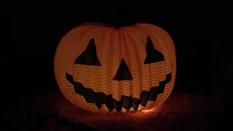Doll pumpkin made of paper glows in the dark. Halloween Stock Footage 219370162