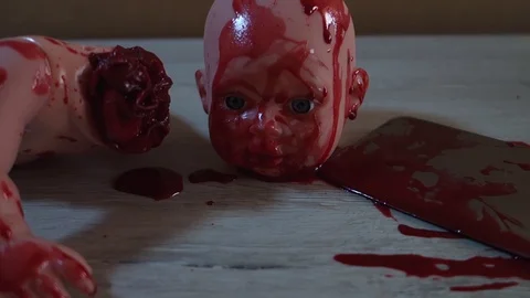 A doll with a severed head in a pool of blood. Bloody knife, halloween concept. Stock Footage 129554574