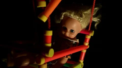 Doll is sitting on a swing Stock Footage 120246879