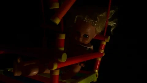 Doll is sitting on a swing, a shadow glides over it Stock Footage 120246870