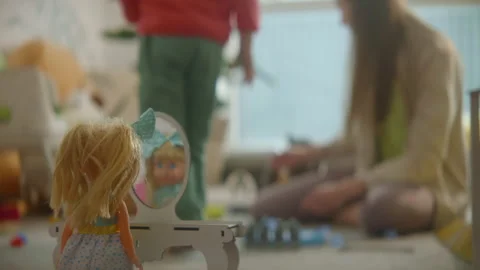 Doll stands at the toy table mirror, mother and daughter playing at nursury Stock Footage 234529415