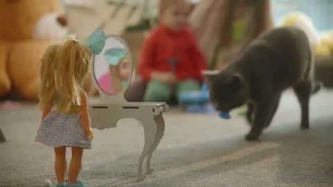 Doll stands at toy table mirror, mom and daughter playing busily on background Stock Footage 255310951