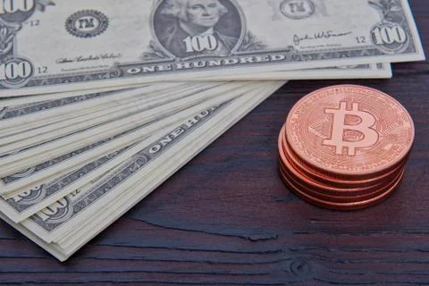 Dollar banknotes and Bitcoins on a table Stock-Fotos