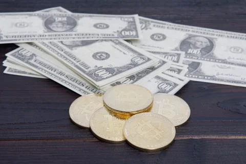Dollar banknotes and Bitcoins on a table Stock Photos