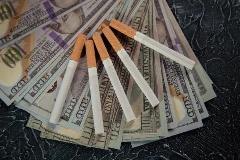 Dollar banknotes and five cigarettes. Expensive and harmful habit concept Stock Photos