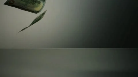 Dollar banknotes falling slowly onto a dark shiny floor Stock Footage 327786913