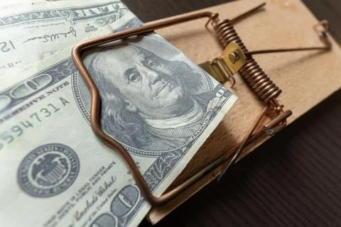 Dollar banknotes in a mouse trap as a bait. Money, finance and scam concept. Stock Photos
