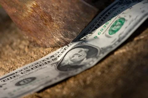 A dollar being cut with an axe Stock Photos