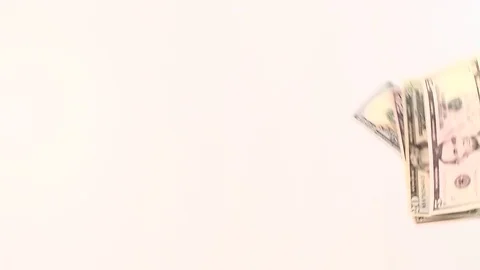Dollar bills of different denominations stacked on a white table. View from Stock Footage 80888866