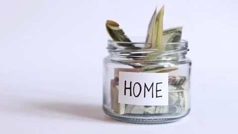 Dollar bills fall into the jar. Glass jar with money on a white background Stock Footage 243288314