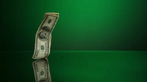 Dollar bills fall slowly onto a green floor. Stock Footage 326629455