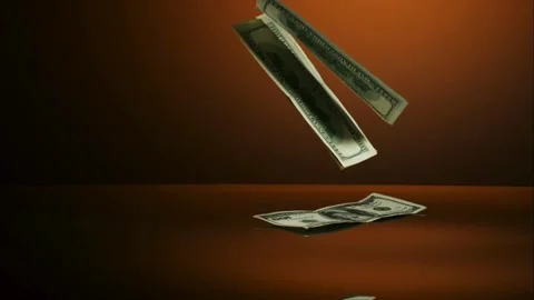 Dollar bills falling onto a reflective surface Stock Footage 327052168