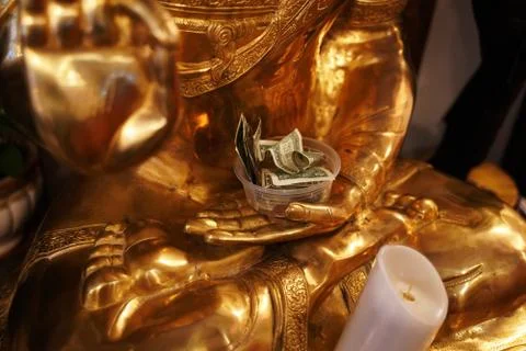 Dollar bills in a plastic container in the hand of Lakshmi, Hindu goddess of  Stock Photos