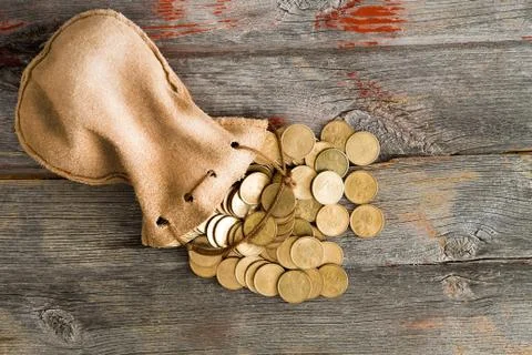 Dollar coins spilling out of a drawstring pouch Stock Photos