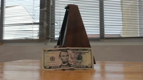 Dollar devaluation and inflation concept. Ticking metronome with five dolla.. Видео 332179160