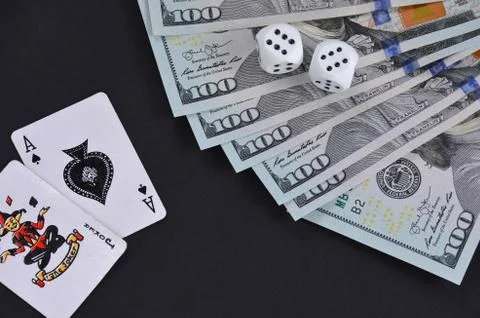 Dollars and dice on a black table.	 Stock Photos