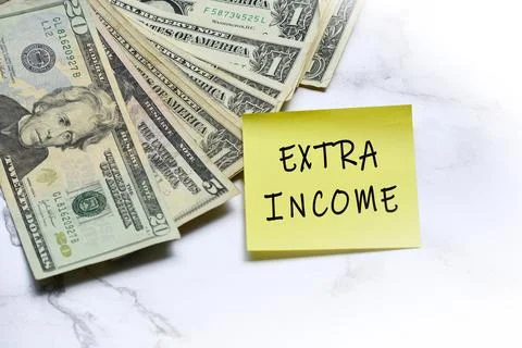 Dollars bill and stick note with text written EXTRA INCOME on mable table. Stock Photos