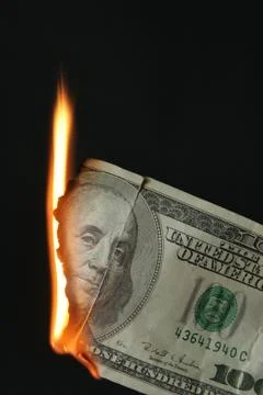 Dollars bill on fire Stock Photos