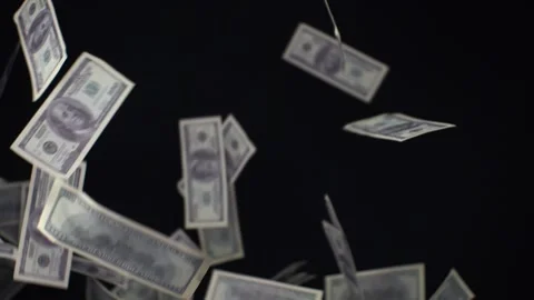 Dollars on a black isolated background fly out from the side and fall down. The Stock Footage 233082706