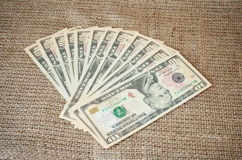 Dollars on a burlap background Stock Photos