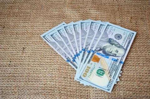 Dollars on a burlap background Stock Photos