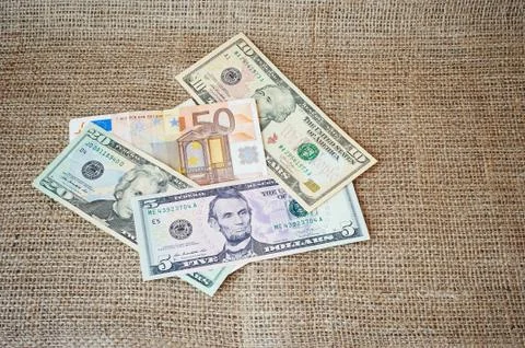 Dollars on a burlap background Stock Photos