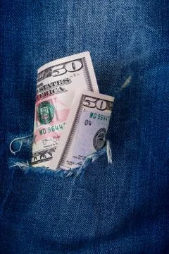 Dollars in a denim hole 库存照片