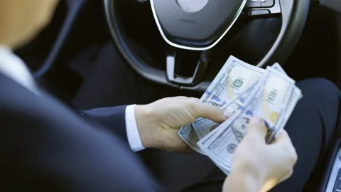 Dollars of different denominations. Man counting money cash at luxury car Video stock 194755523