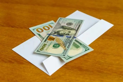 Dollars in an envelope on a wooden table Stock Photos