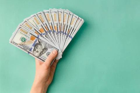 Dollars in hands on green background top view copy space Stock Photos