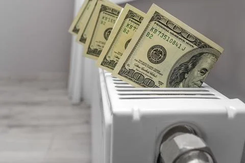 Dollars on the heater. Payment for heating. Stock Photos