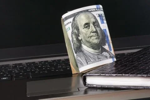 Dollars, laptop and notebook Stock Photos