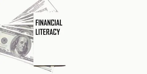 Dollars on a light background, a notepad with the text FINANCIAL LITERACY. Bu Stock Photos