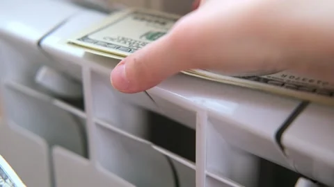 Dollars money banknotes are on heating radiator battery. Concept of expensive Stock Footage 273482010