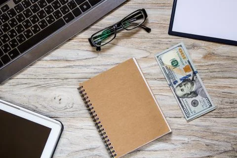 Dollars with office objects on the light wooden table Stock Photos