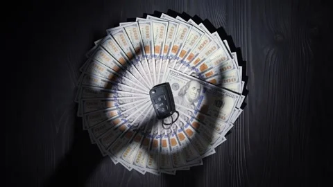 Dollars stacked in a circle, shadows of hands trying to take the key. Video stock 262521514