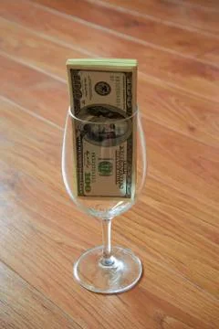 Dollars in wineglass Stock Photos